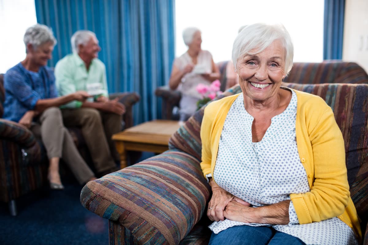 Residents and a caregiver sharing the living room of a small residential care home